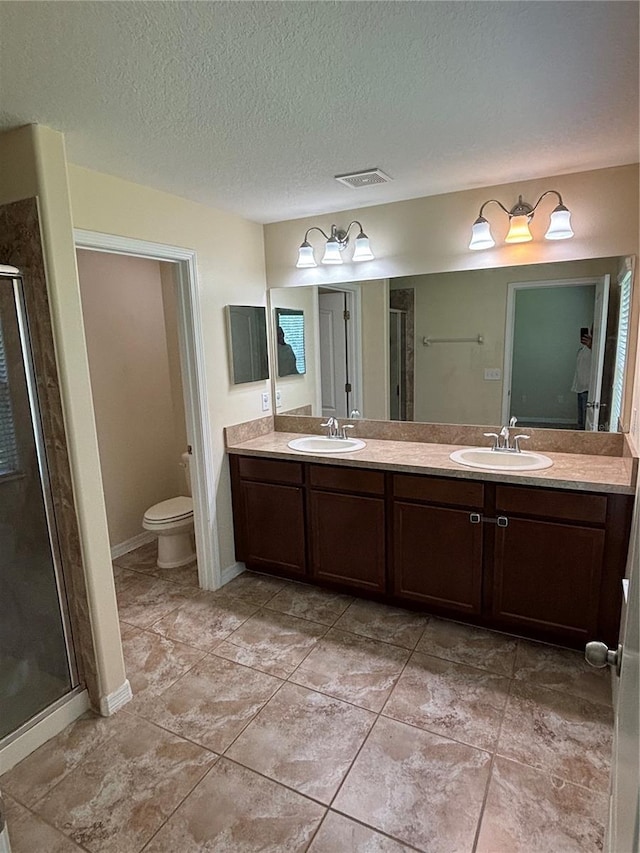 11187 Savannah Landing Cir, Orlando, FL 32832 - bathroom with double vanity, a stall shower, toilet, a textured ceiling, and tile patterned flooring