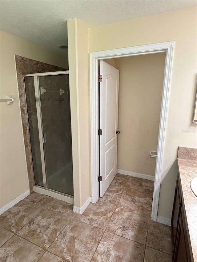 11187 Savannah Landing Cir, Orlando, FL 32832 - bathroom with vanity, a stall shower, baseboards, and a textured ceiling