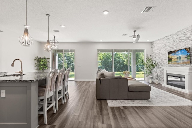 2340 Standing Rock Cir, Oakland, FL 34787 - living area with a textured ceiling, dark wood finished floors, a glass covered fireplace, baseboards, and recessed lighting