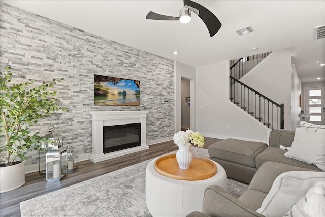 2340 Standing Rock Cir, Oakland, FL 34787 - living area with wood finished floors, ceiling fan, stairs, a glass covered fireplace, and baseboards