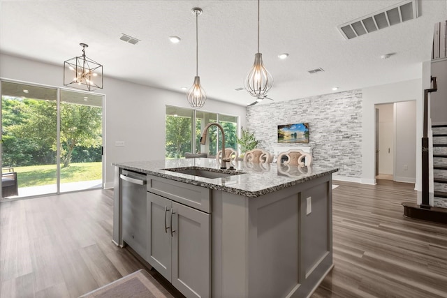 2340 Standing Rock Cir, Oakland, FL 34787 - kitchen featuring a sink, dishwasher, gray cabinetry, dark wood-style floors, and light stone countertops