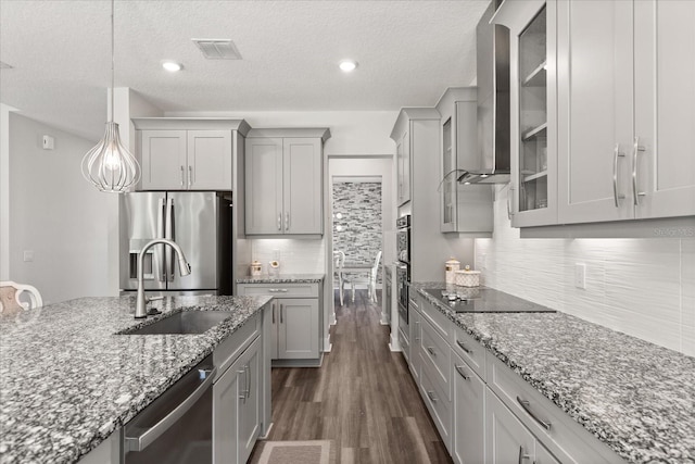 2340 Standing Rock Cir, Oakland, FL 34787 - kitchen with stainless steel appliances, a sink, gray cabinets, wall chimney exhaust hood, and a textured ceiling