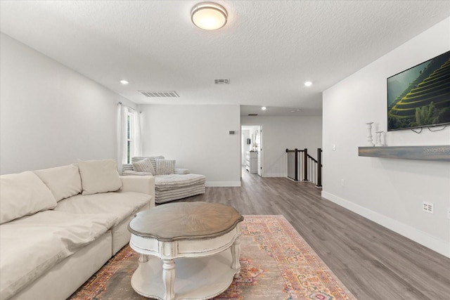 2340 Standing Rock Cir, Oakland, FL 34787 - living room featuring wood finished floors, a textured ceiling, recessed lighting, and baseboards