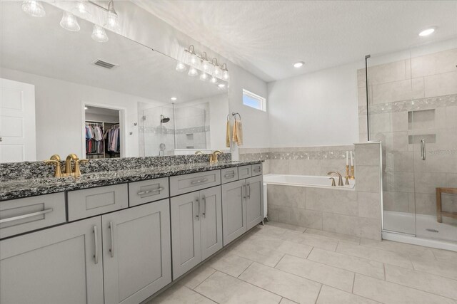 2340 Standing Rock Cir, Oakland, FL 34787 - bathroom with a shower stall, a garden tub, double vanity, tile patterned floors, and a spacious closet