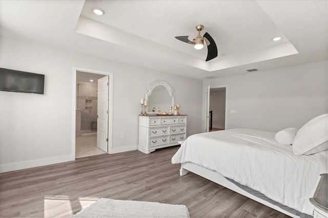 2340 Standing Rock Cir, Oakland, FL 34787 - bedroom featuring a raised ceiling, recessed lighting, baseboards, wood finished floors, and ensuite bathroom