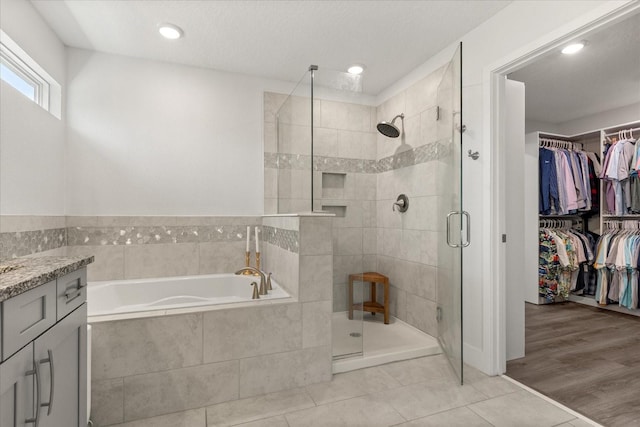 2340 Standing Rock Cir, Oakland, FL 34787 - bathroom with a garden tub, a shower stall, a spacious closet, tile patterned floors, and vanity