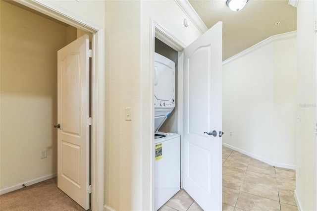 909 Charo Pkwy Unit 1011, Davenport, FL 33897 - washroom with stacked washer and clothes dryer, light tile patterned flooring, and baseboards