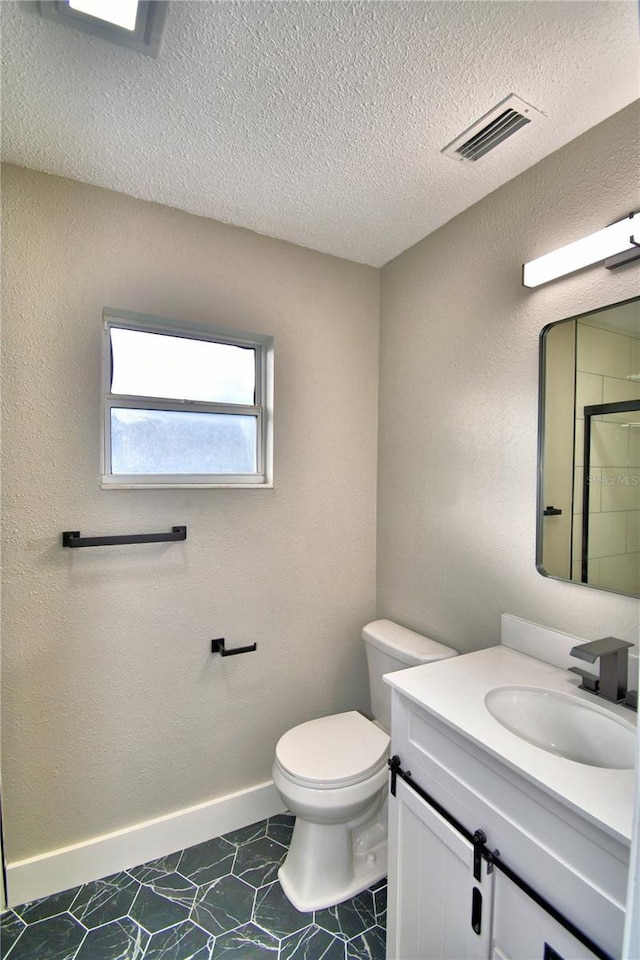 7504 Willow Wisp Dr E, Lakeland, FL 33810 - bathroom featuring vanity, toilet, a textured ceiling, and baseboards