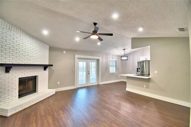 7504 Willow Wisp Dr E, Lakeland, FL 33810 - unfurnished living room featuring dark wood finished floors, ceiling fan, a textured ceiling, baseboards, and a brick fireplace