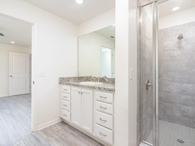 3124 N Chamberlain Blvd, North Port, FL 34286 - bathroom featuring a shower stall, vanity, wood finished floors, recessed lighting, and baseboards