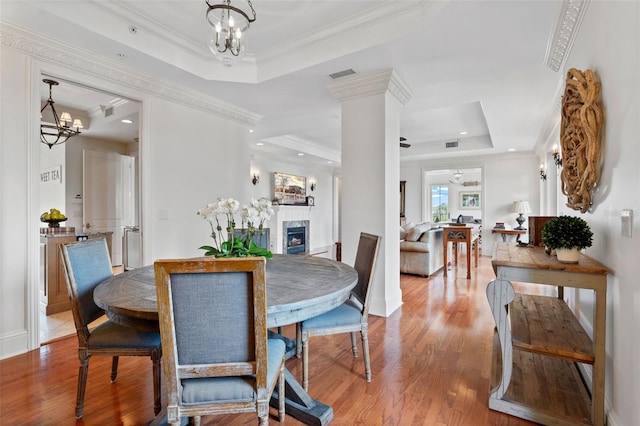 140 E Morse Blvd Unit J, Winter Park, FL 32789 - dining room with a raised ceiling, a fireplace, wood finished floors, a chandelier, and crown molding