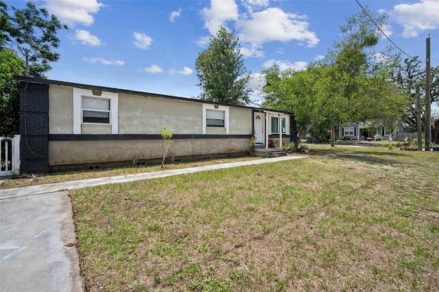 1711 E Sewaha St, Tampa, FL 33612 - view of front of house with stucco siding, a front lawn, and crawl space