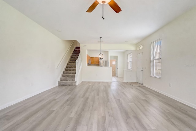 4178 SW 43rd Cir, Ocala, FL 34474 - unfurnished living room featuring stairway, light wood-style flooring, a ceiling fan, and baseboards
