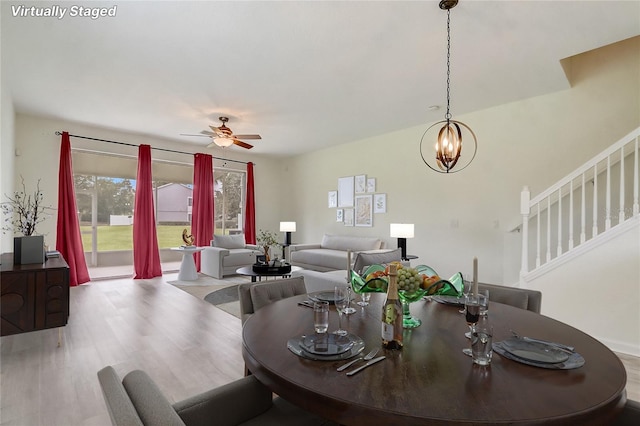 4178 SW 43rd Cir, Ocala, FL 34474 - dining room with wood finished floors, stairs, ceiling fan, and a chandelier