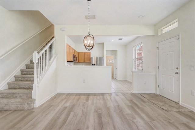 4178 SW 43rd Cir, Ocala, FL 34474 - entryway featuring stairs, light wood-style floors, a chandelier, and baseboards
