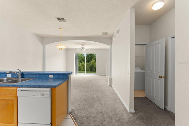 214 Monroe Cir, Davenport, FL 33896 - kitchen featuring white dishwasher, washer / dryer, a sink, light colored carpet, and dark countertops
