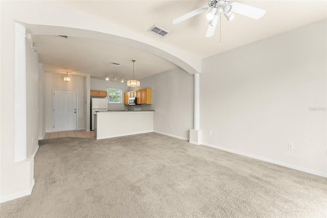 214 Monroe Cir, Davenport, FL 33896 - unfurnished living room featuring light carpet, a ceiling fan, track lighting, arched walkways, and baseboards