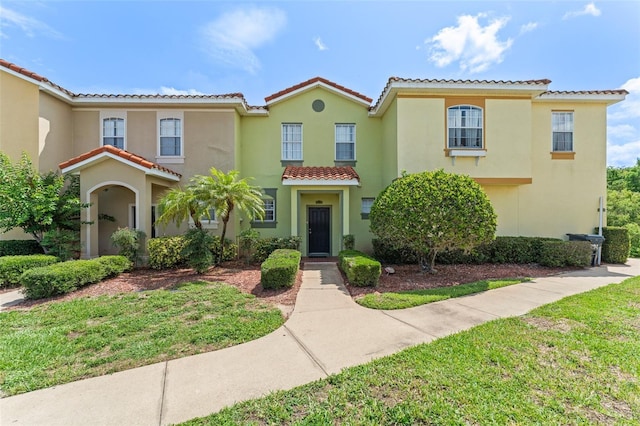 214 Monroe Cir, Davenport, FL 33896 - view of front facade featuring a tile roof, stucco siding, and a front lawn