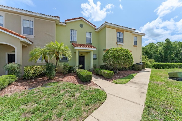214 Monroe Cir, Davenport, FL 33896 - view of front of house featuring a tiled roof, stucco siding, a front lawn, and cooling unit