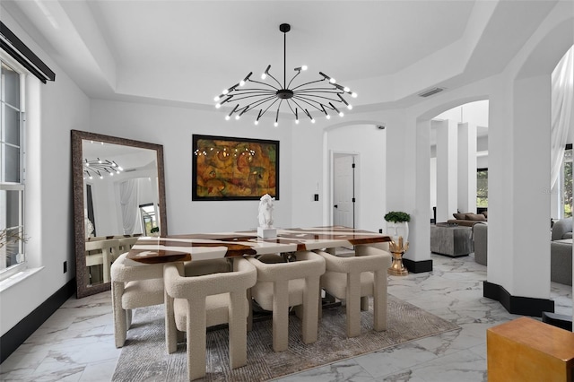 8131 Vineland Oaks Blvd, Orlando, FL 32835 - dining space with light marble finish floors, arched walkways, a raised ceiling, and a chandelier