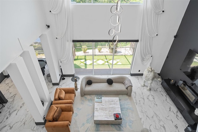 8131 Vineland Oaks Blvd, Orlando, FL 32835 - living area featuring a high ceiling, marble tiled flooring, plenty of natural light, and a chandelier