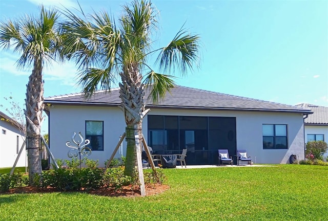 410 SE Vallarta Dr, Port St Lucie, FL 34984 - rear view of property with a yard, stucco siding, a tiled roof, and a sunroom
