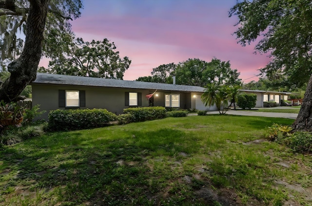 310 E Gulley Ave, Oakland, FL 34760 - ranch-style home featuring stucco siding, a lawn, and driveway