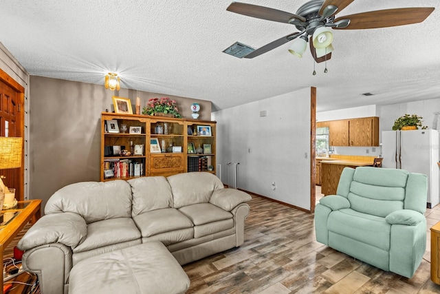 310 E Gulley Ave, Oakland, FL 34760 - living area with wood finished floors, a ceiling fan, and a textured ceiling