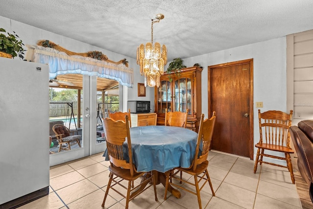 310 E Gulley Ave, Oakland, FL 34760 - dining area featuring french doors, a chandelier, light tile patterned floors, and a textured ceiling