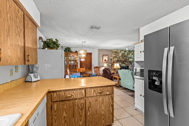 310 E Gulley Ave, Oakland, FL 34760 - kitchen featuring white appliances, a peninsula, light countertops, light tile patterned flooring, and open floor plan