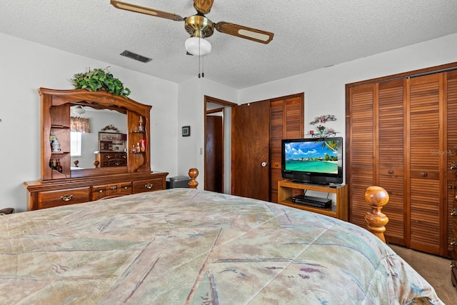 310 E Gulley Ave, Oakland, FL 34760 - bedroom featuring two closets, a textured ceiling, and a ceiling fan