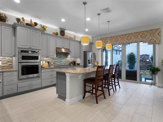 8818 Bismarck Palm Dr, Winter Garden, FL 34787 - kitchen with gray cabinetry, stainless steel appliances, under cabinet range hood, and recessed lighting