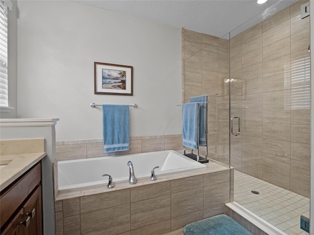 8818 Bismarck Palm Dr, Winter Garden, FL 34787 - bathroom featuring vanity, a garden tub, a stall shower, and a textured ceiling