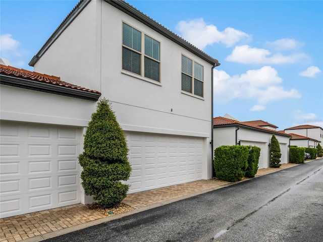 8818 Bismarck Palm Dr, Winter Garden, FL 34787 - mediterranean / spanish-style home with stucco siding, a tile roof, and a garage