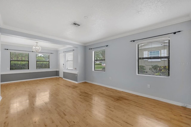 1021 N Forest Ave, Orlando, FL 32803 - spare room with a chandelier, light wood-style floors, crown molding, baseboards, and a textured ceiling