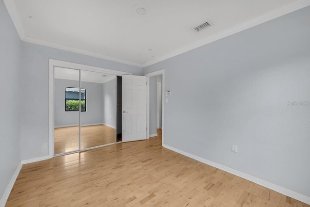 1021 N Forest Ave, Orlando, FL 32803 - unfurnished bedroom featuring ornamental molding, baseboards, light wood finished floors, and a closet