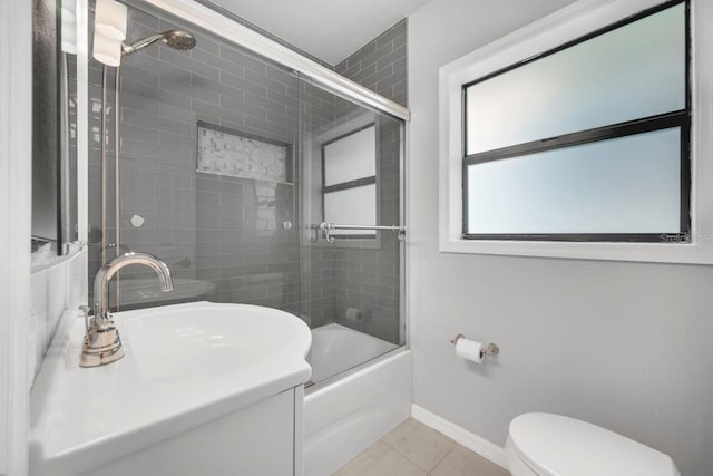 1021 N Forest Ave, Orlando, FL 32803 - full bathroom with tile patterned flooring, toilet, combined bath / shower with glass door, baseboards, and a sink