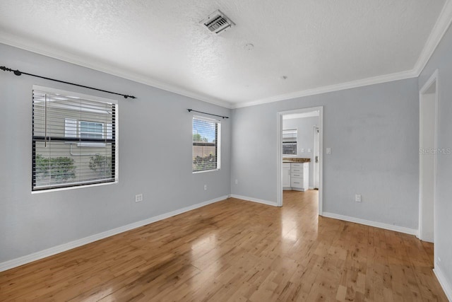 1021 N Forest Ave, Orlando, FL 32803 - unfurnished room featuring crown molding, light wood finished floors, a textured ceiling, and baseboards