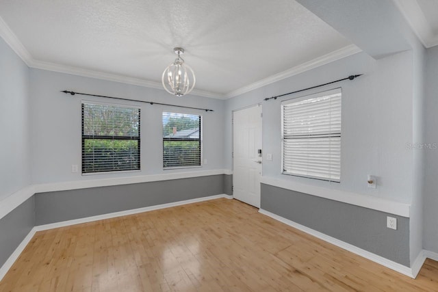 1021 N Forest Ave, Orlando, FL 32803 - spare room featuring a chandelier, light wood-type flooring, ornamental molding, baseboards, and a textured ceiling