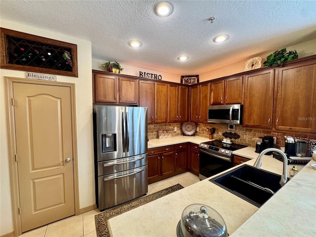 10350 Lake District Ln Unit S, Orlando, FL 32832 - kitchen featuring appliances with stainless steel finishes, a sink, light tile patterned floors, light countertops, and backsplash