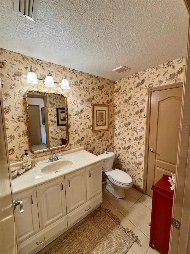 10350 Lake District Ln Unit S, Orlando, FL 32832 - half bath featuring tile patterned flooring, vanity, toilet, wallpapered walls, and a textured ceiling