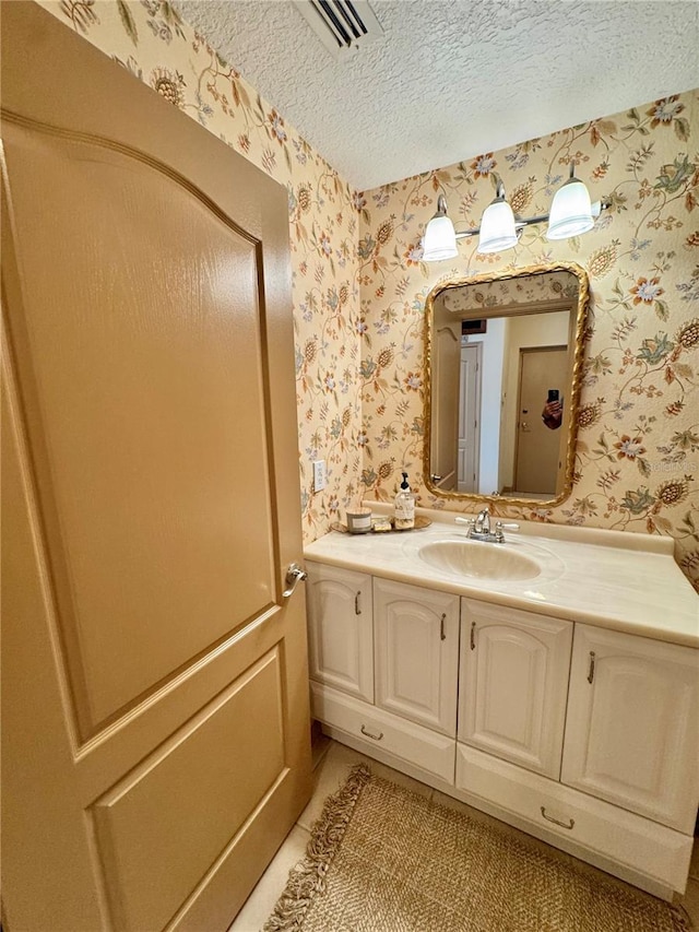 10350 Lake District Ln Unit S, Orlando, FL 32832 - bathroom featuring wallpapered walls, vanity, a textured ceiling, and tile patterned flooring