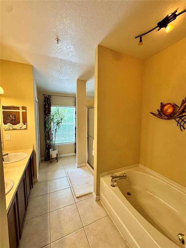 10350 Lake District Ln Unit S, Orlando, FL 32832 - bathroom with a textured ceiling, a garden tub, tile patterned floors, double vanity, and a stall shower
