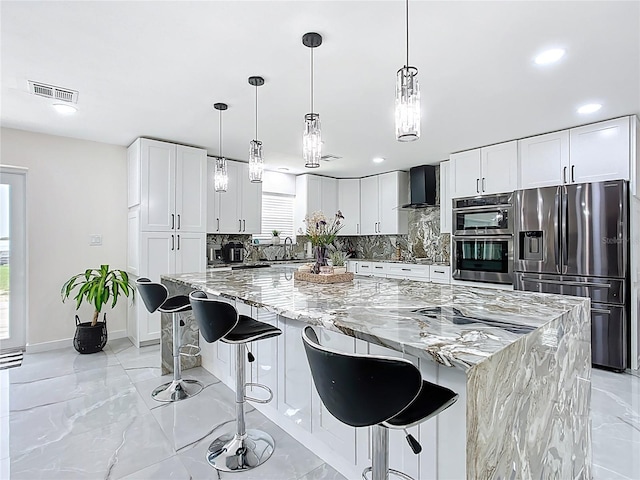 516 Petes Ln, Davenport, FL 33837 - kitchen featuring stainless steel appliances, wall chimney range hood, tasteful backsplash, light stone countertops, and recessed lighting