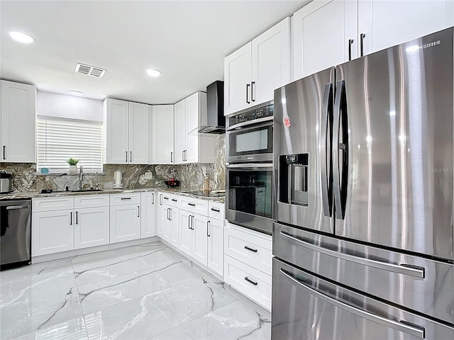 516 Petes Ln, Davenport, FL 33837 - kitchen with appliances with stainless steel finishes, wall chimney range hood, decorative backsplash, white cabinets, and recessed lighting