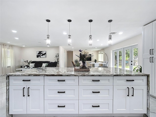 516 Petes Ln, Davenport, FL 33837 - kitchen with dark stone countertops, white cabinetry, open floor plan, decorative light fixtures, and recessed lighting