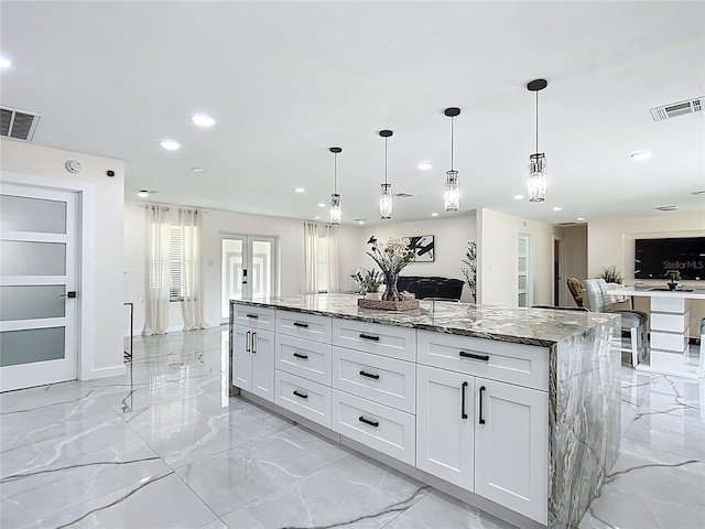 516 Petes Ln, Davenport, FL 33837 - kitchen featuring stone counters, recessed lighting, light marble finish floors, french doors, and open floor plan