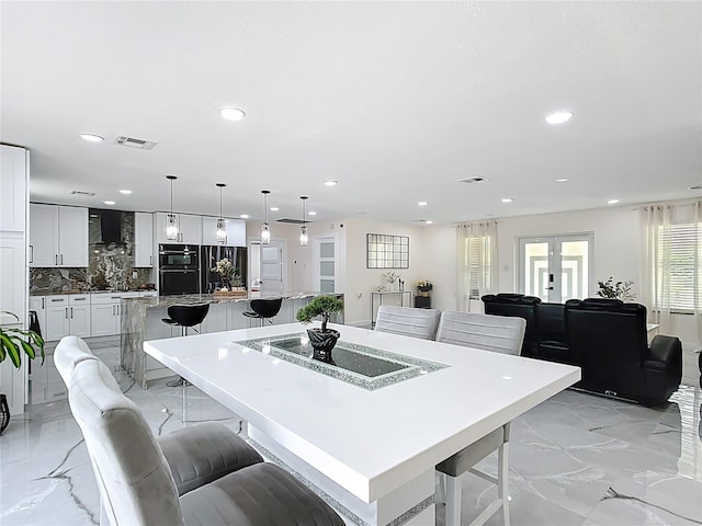 516 Petes Ln, Davenport, FL 33837 - kitchen featuring a spacious island, a kitchen breakfast bar, wall chimney range hood, recessed lighting, and tasteful backsplash