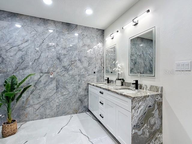 516 Petes Ln, Davenport, FL 33837 - bathroom with double vanity, marble tiled flooring, and recessed lighting