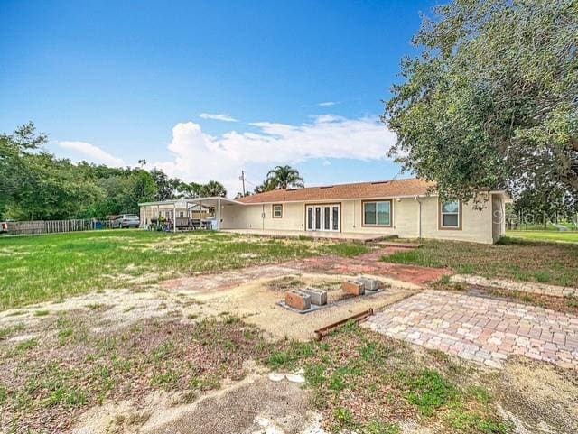 516 Petes Ln, Davenport, FL 33837 - rear view of property featuring stucco siding, french doors, and a lawn